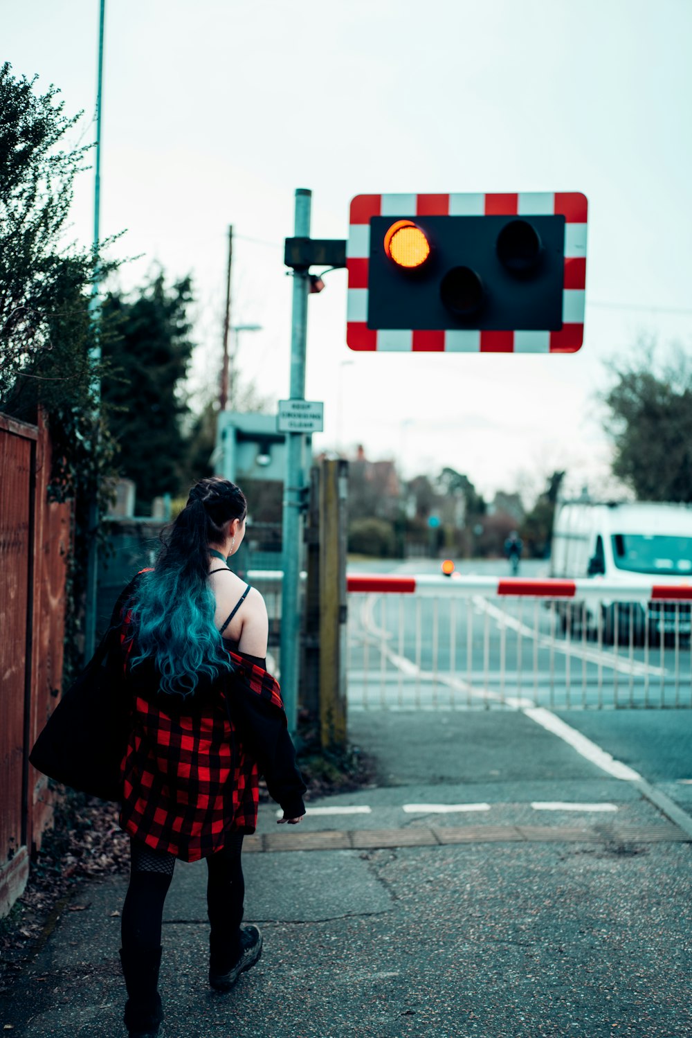 woman in red and black dress standing on sidewalk during daytime