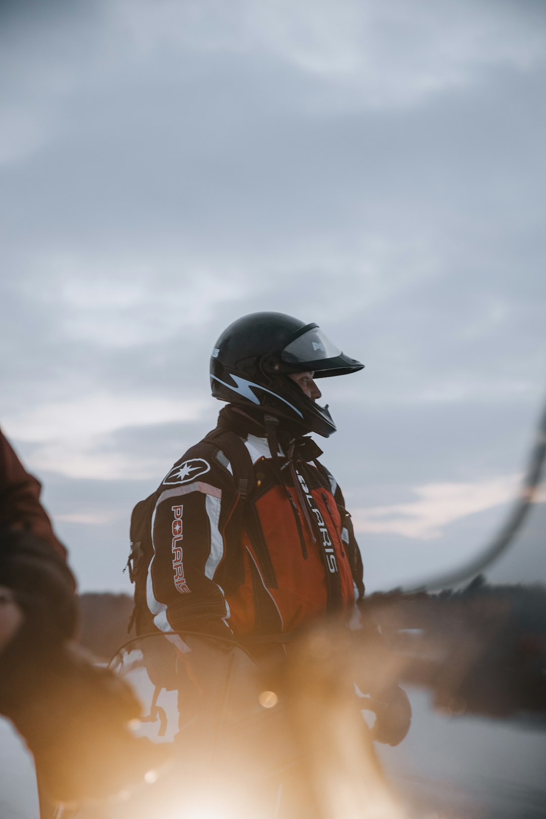 man in orange jacket wearing black helmet