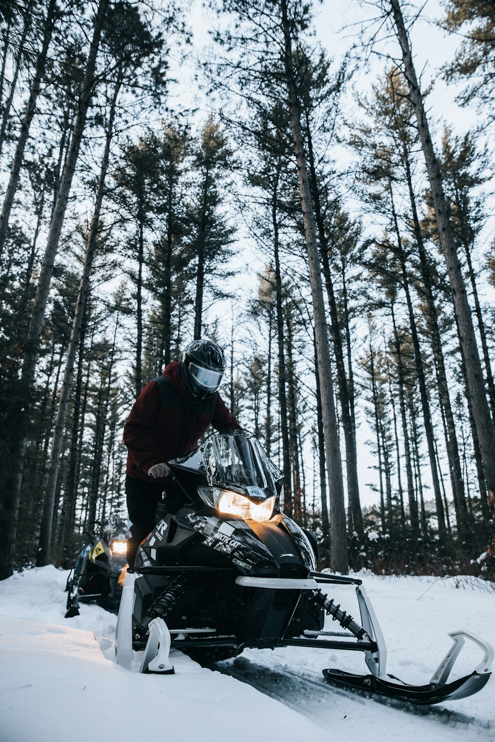 man riding motorcycle on snow covered ground during daytime