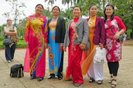 A group of women laughing together, each dressed in different colorful ethnic wear from the collection.