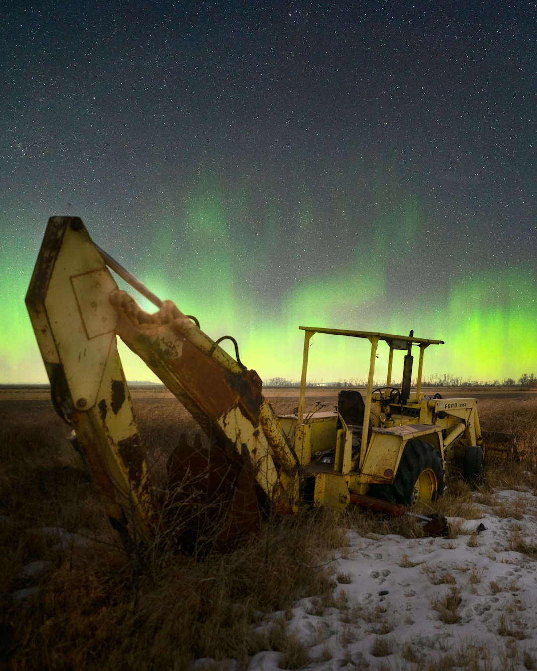 yellow and black heavy equipment on snow covered ground during night time