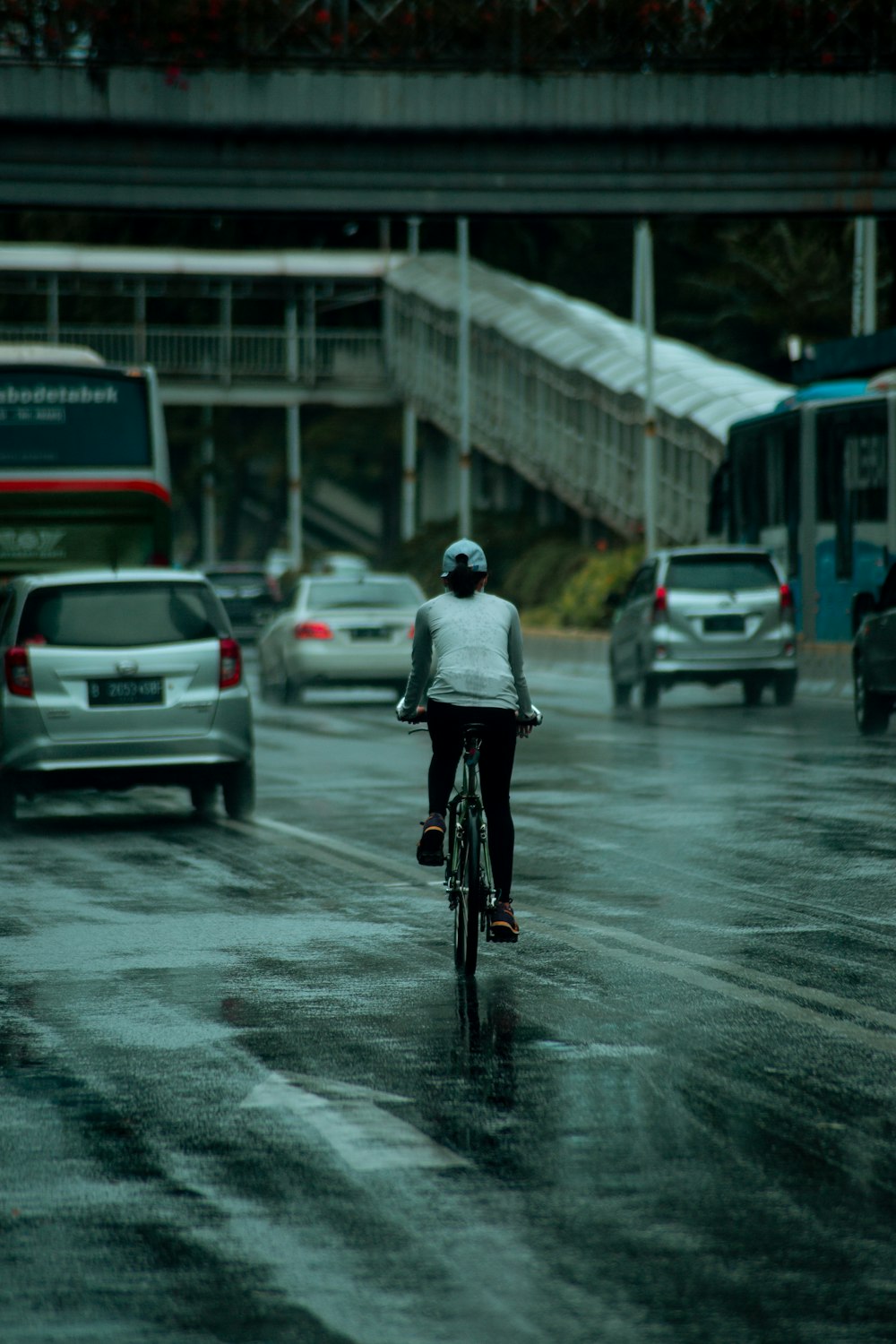 man in white jacket riding bicycle on road during daytime