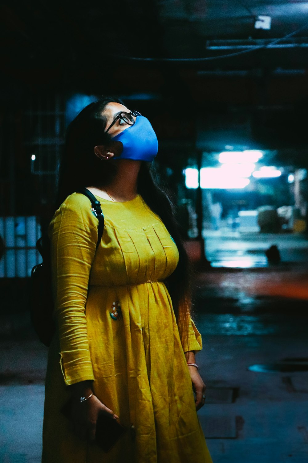 Femme en chemise à manches longues jaune et lunettes bleues