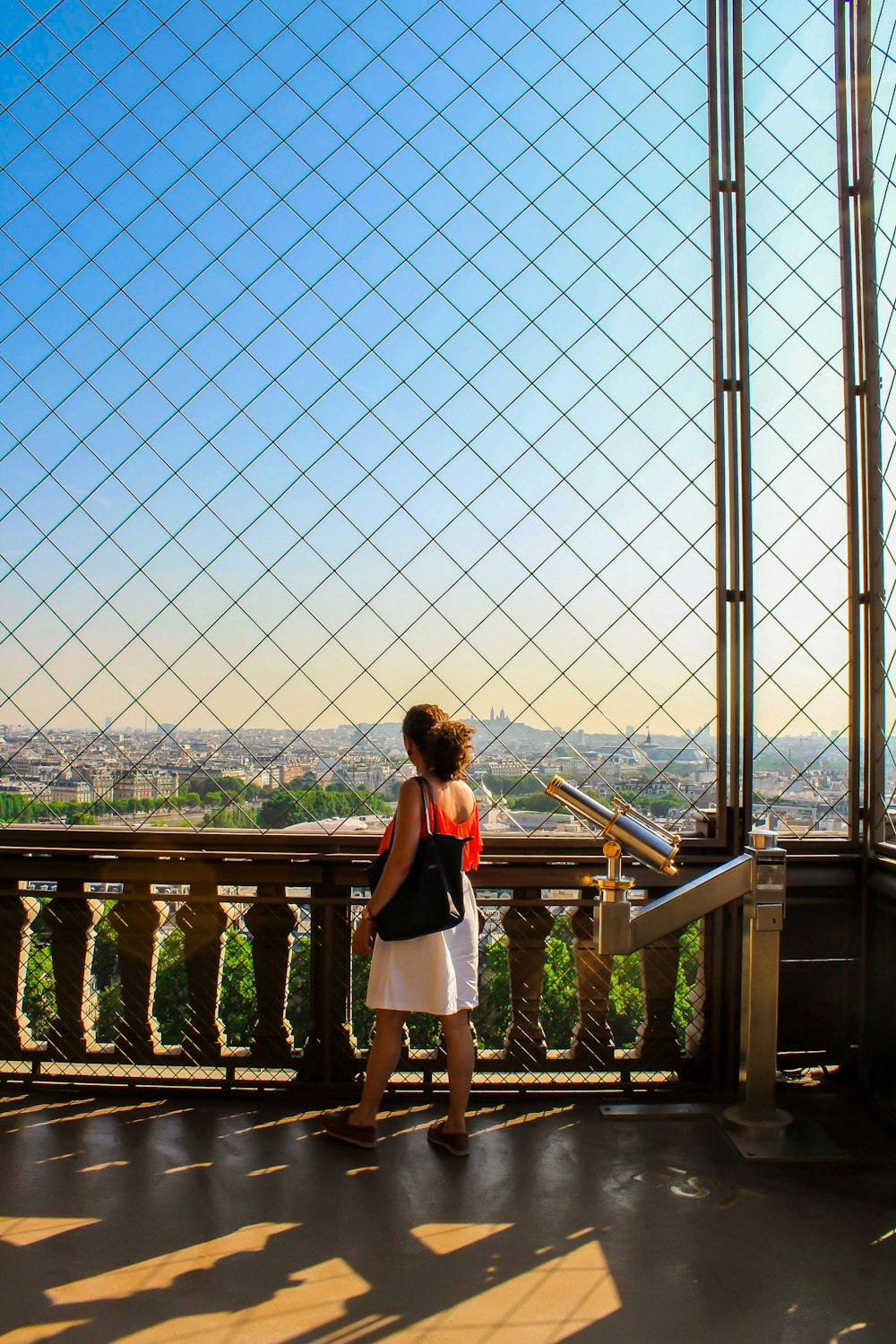 woman in white dress standing on brown wooden bridge