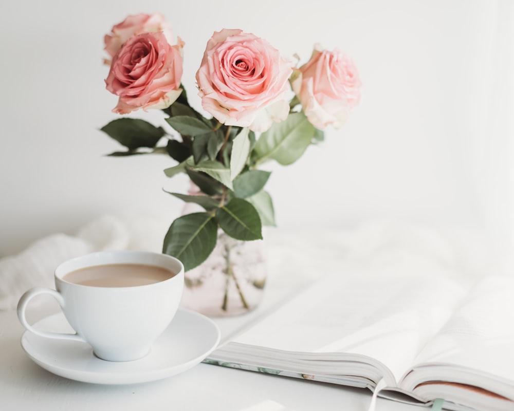 pink roses on white ceramic cup on white ceramic saucer