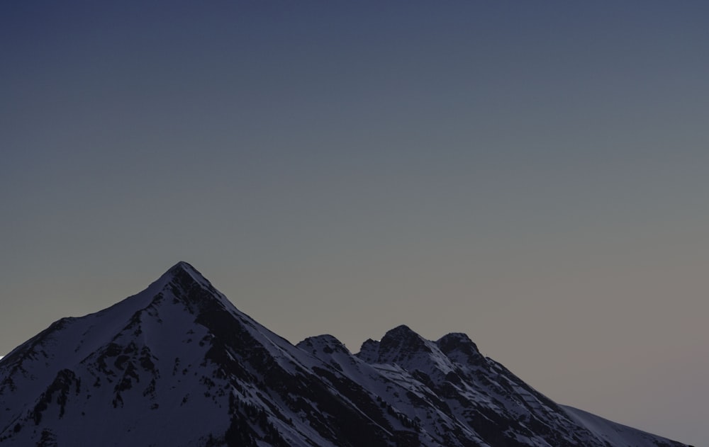 montanha coberta de neve sob o céu azul durante o dia