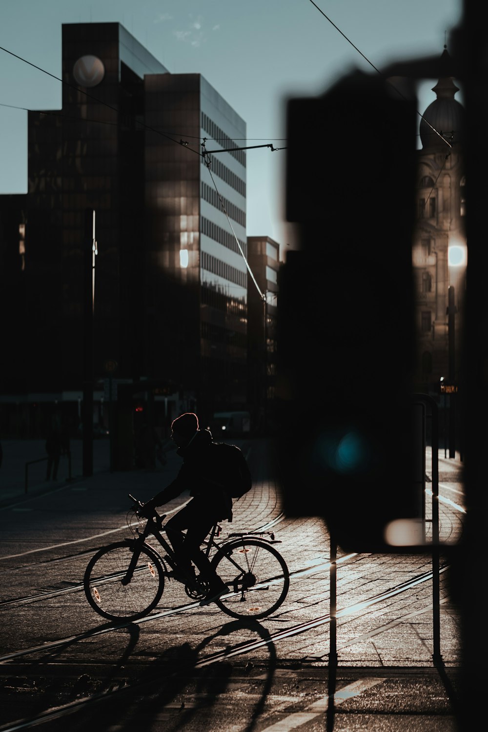 man in black jacket riding bicycle on road during night time