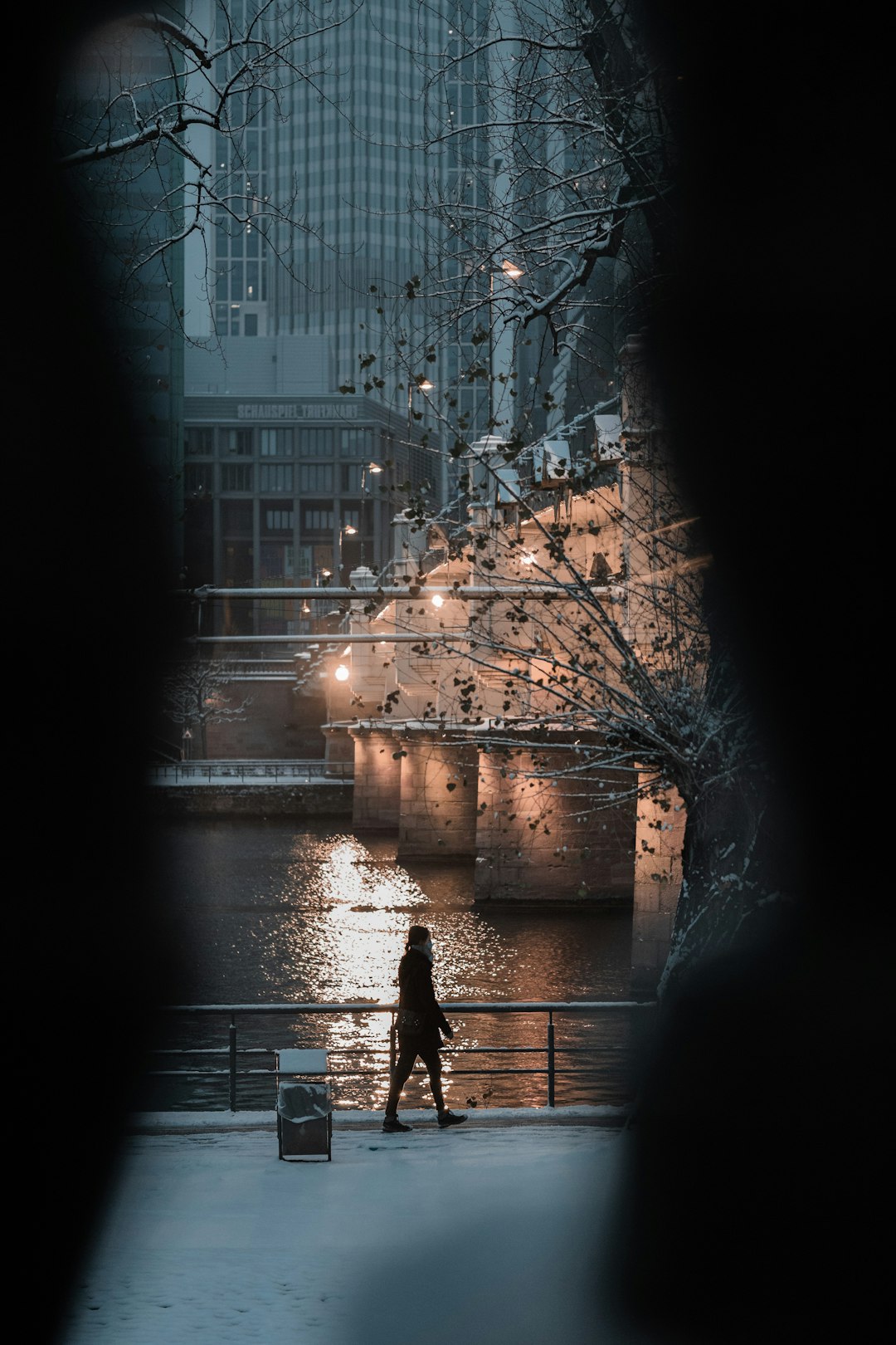 silhouette of person walking on sidewalk during night time