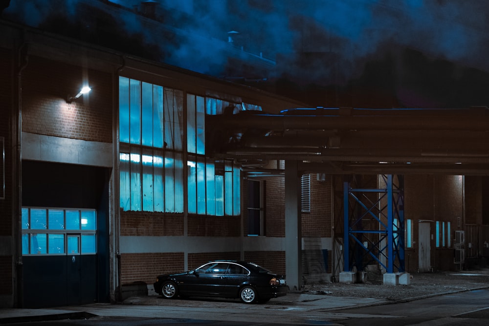 black sedan parked beside building during night time