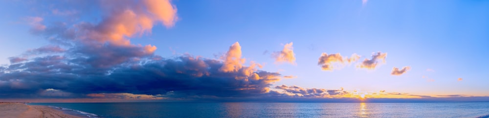 昼間の青い空と白い雲の下の青い海