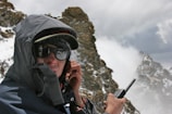 man in black jacket holding black smartphone