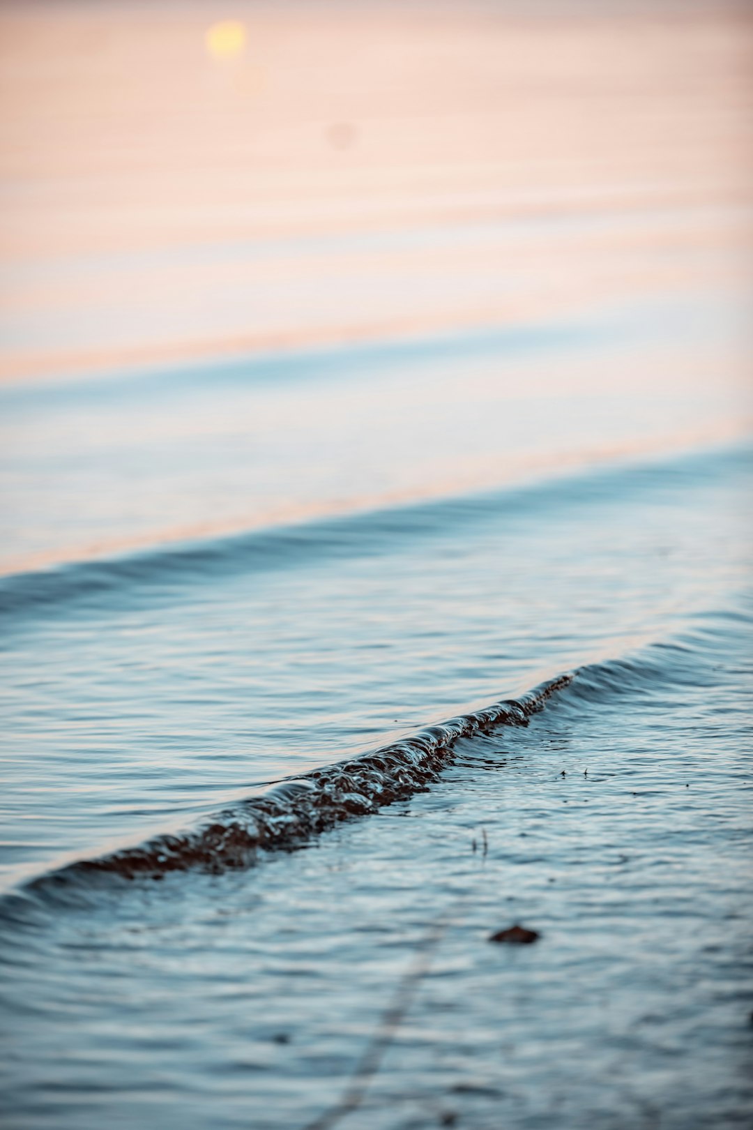 sea waves crashing on shore during sunset