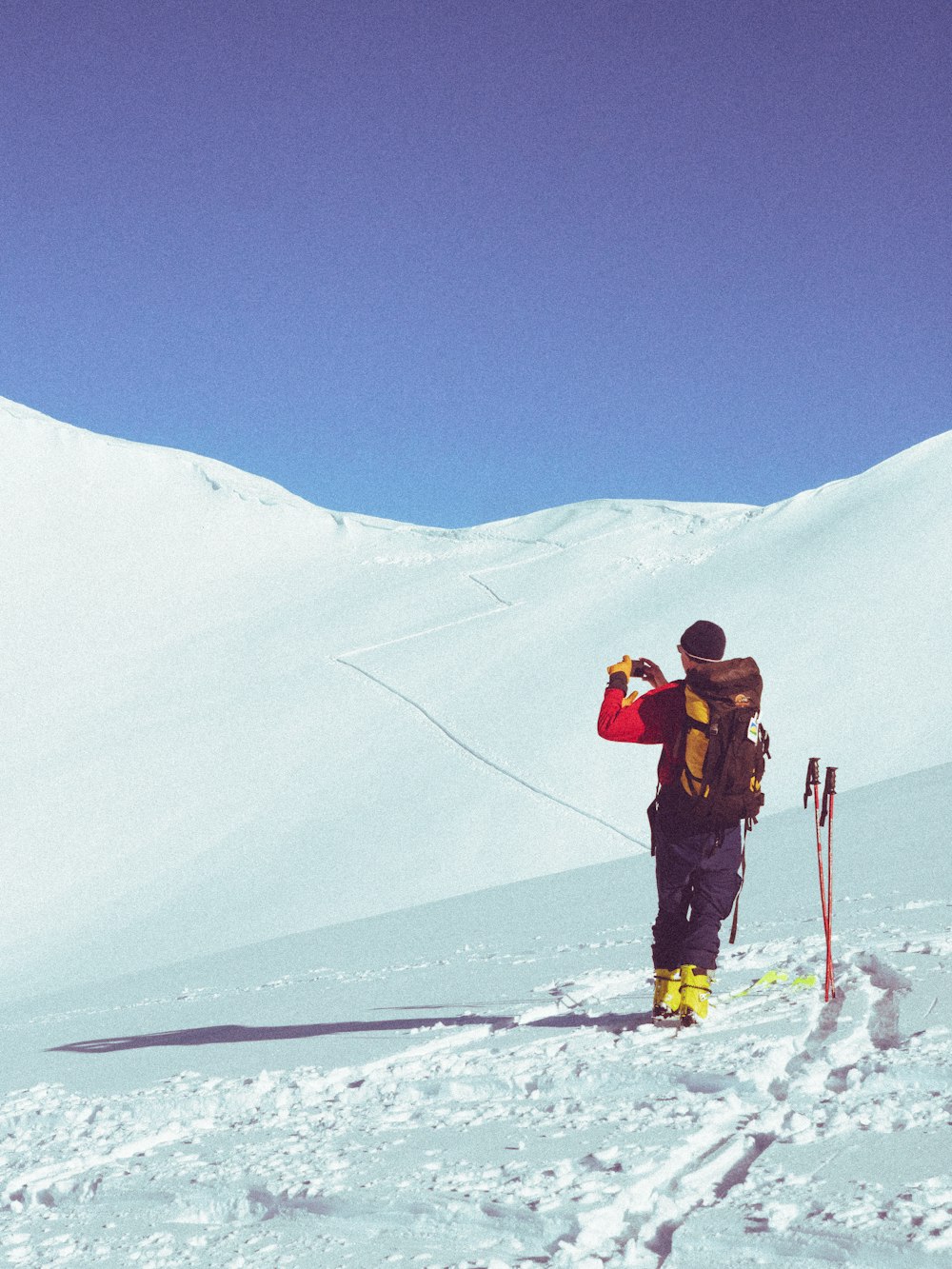 2 men in red jacket and black pants standing on snow covered ground during daytime