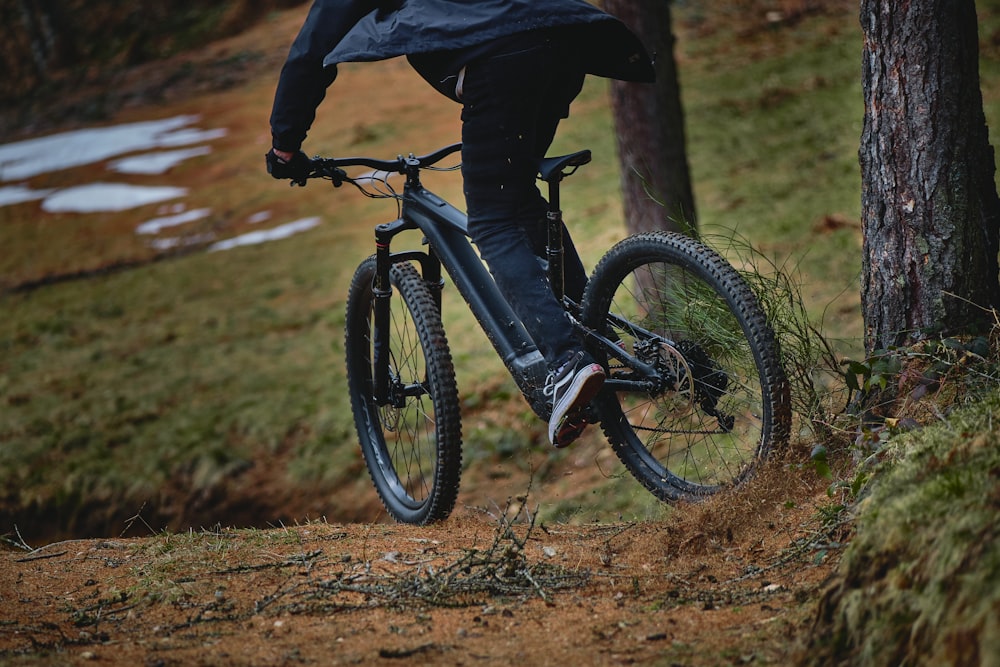 person in black jacket riding black mountain bike