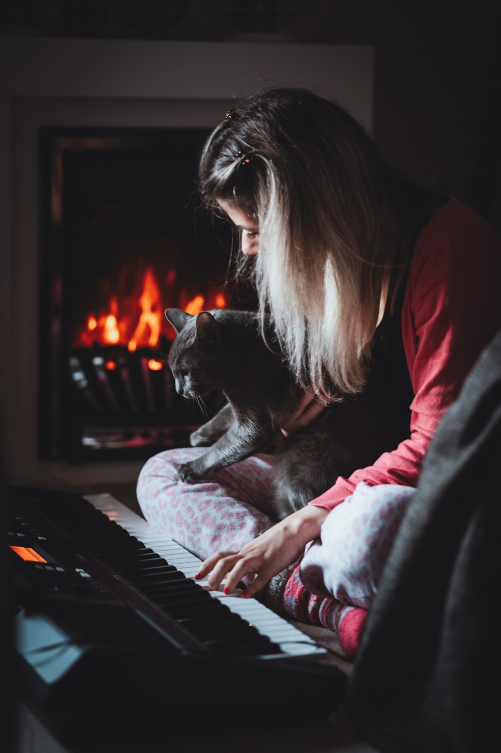 woman in red long sleeve shirt playing piano