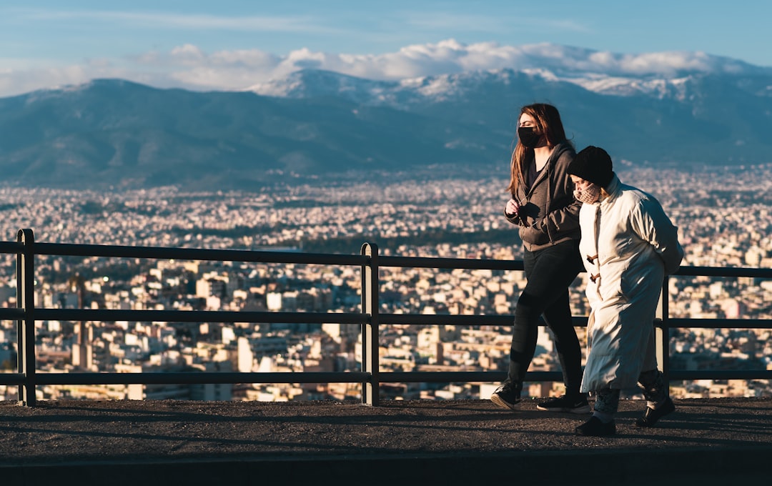 man and woman standing on brown wooden bridge during daytime