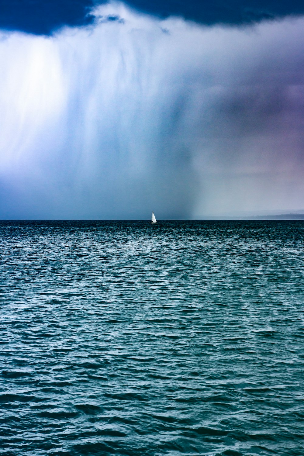 white sailboat on sea under blue sky during daytime