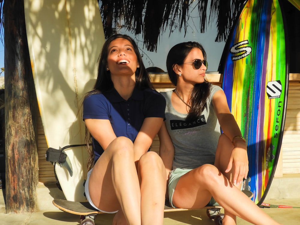 2 women sitting on white chair