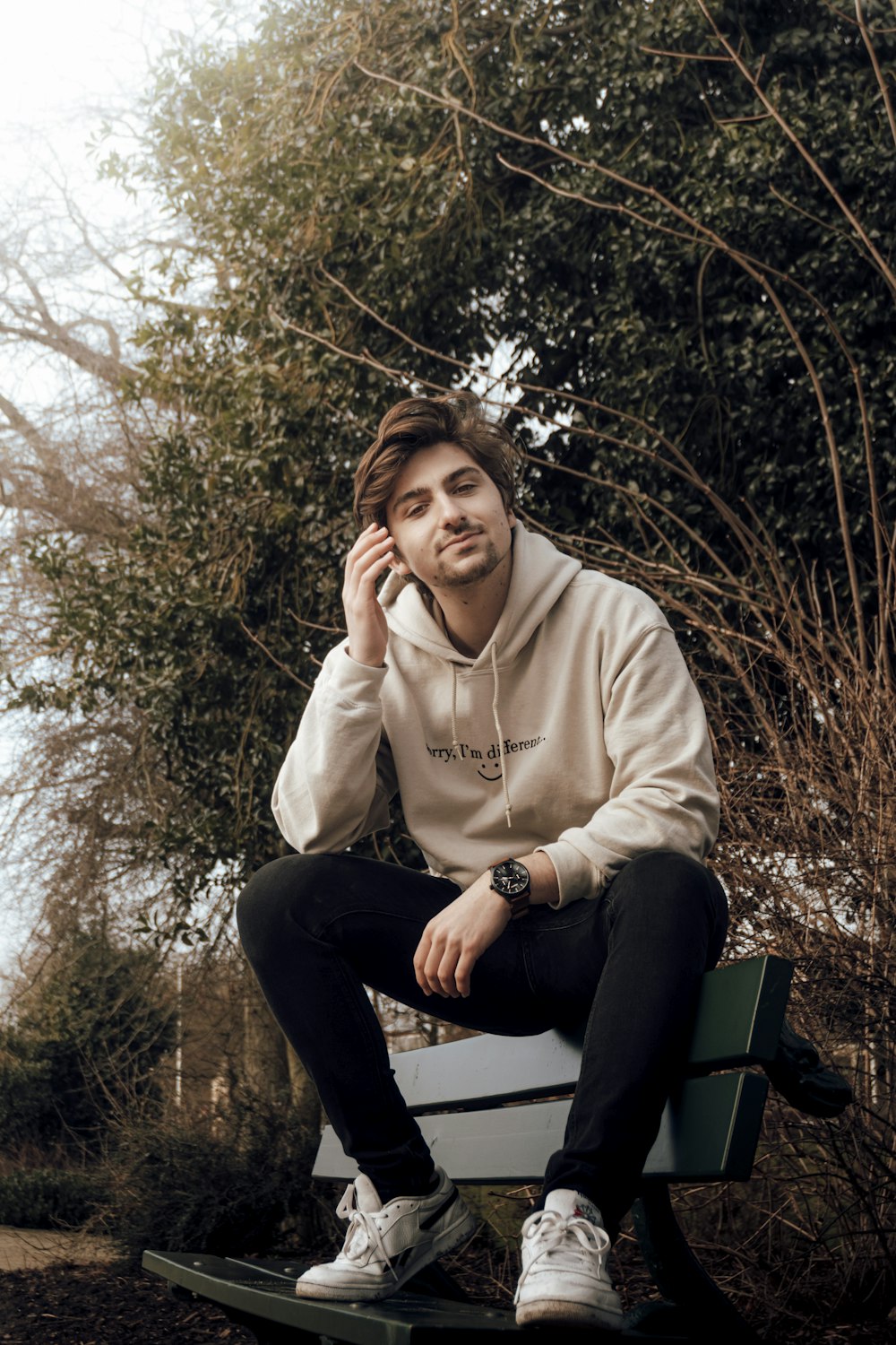 femme en sweat à capuche gris assis sur un banc noir