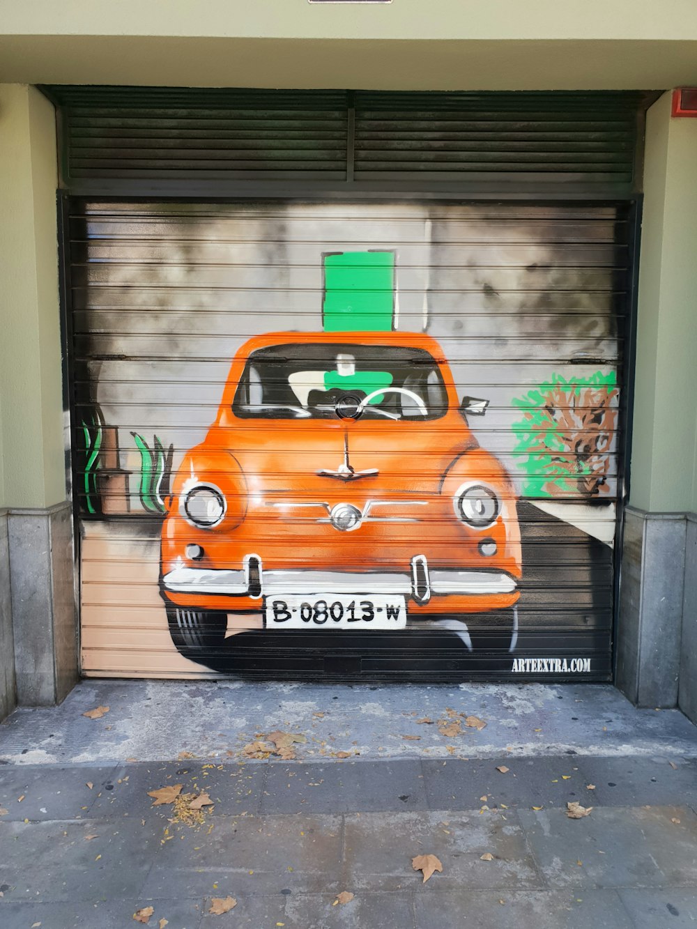 orange volkswagen beetle parked beside gray building