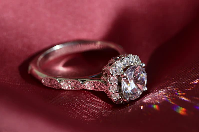 Close-up of a delicate silver ring with a small gemstone on a soft velvet cushion