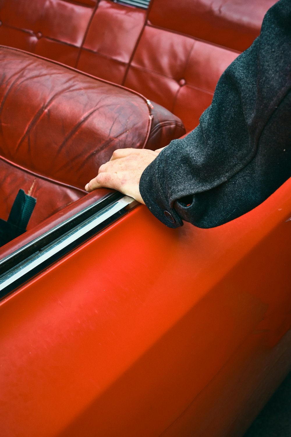 person in black pants sitting on brown leather couch