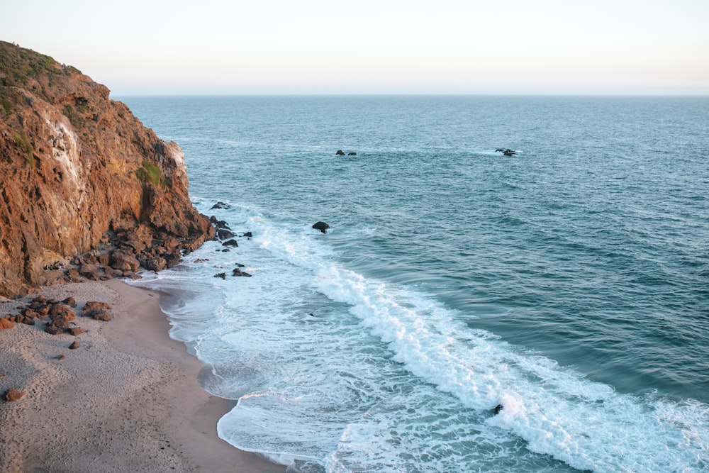 sea waves crashing on shore during daytime