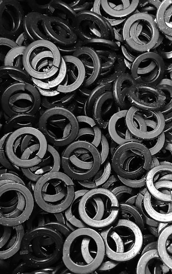 Close-up of shiny mild steel washers neatly arranged on a wooden surface.