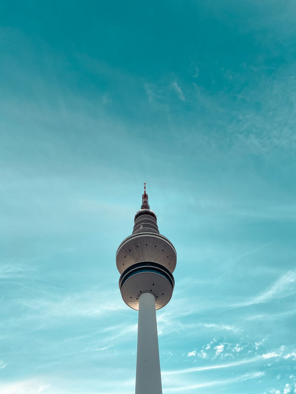 white and red tower under white clouds and blue sky during daytime