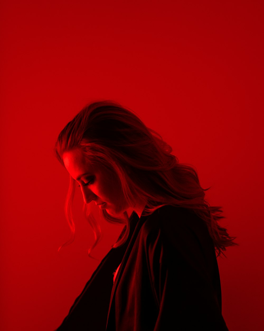 a woman standing in front of a red background