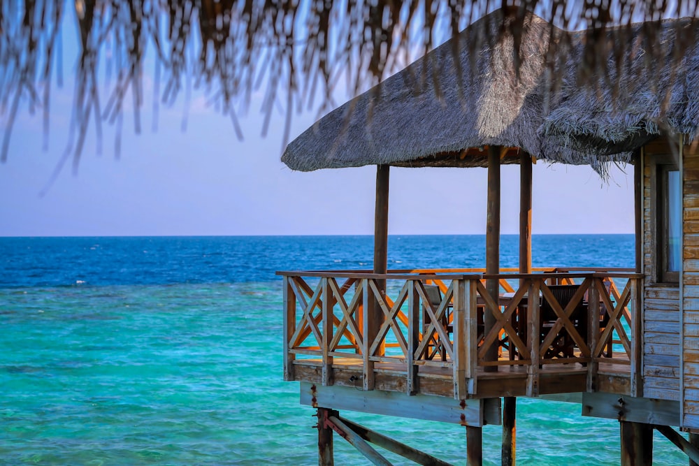 Pontile di legno marrone sulla spiaggia sul mare blu durante il giorno