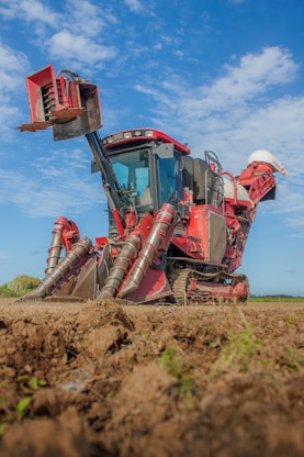 red and brown heavy equipment on brown field during daytime