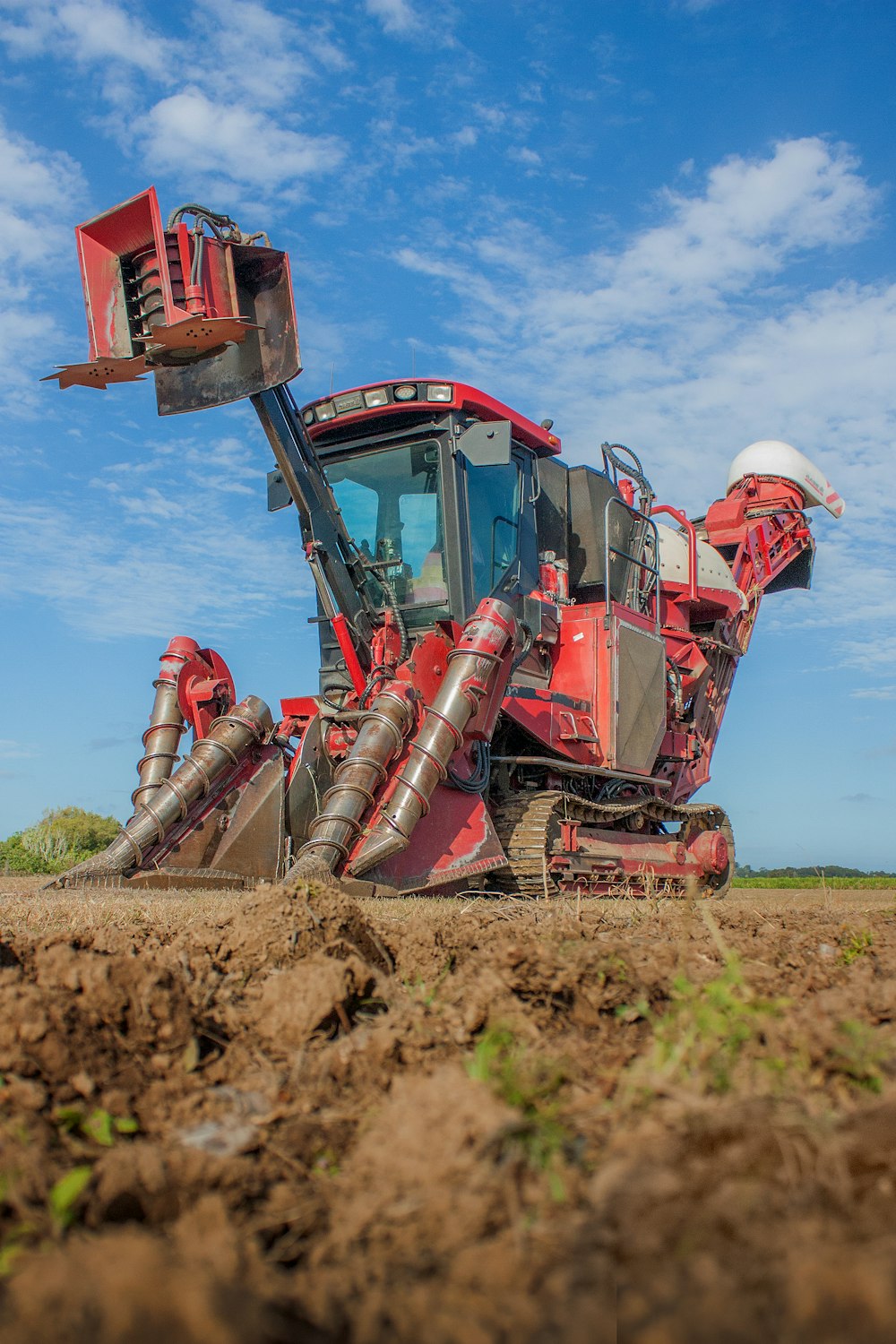 red and brown heavy equipment on brown field during daytime