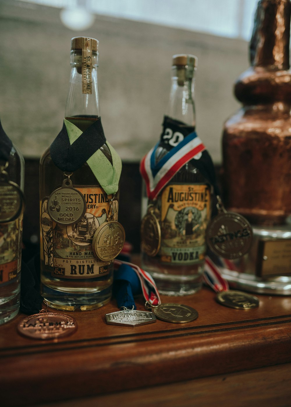 three bottles of alcohol sitting on top of a wooden table