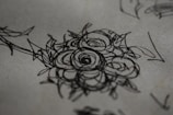 Tattoo design sketch blending floral and natural elements on textured paper.