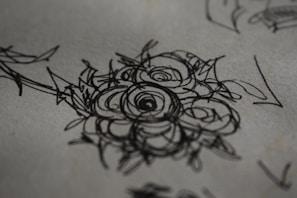 Tattoo design sketch blending floral and natural elements on textured paper.