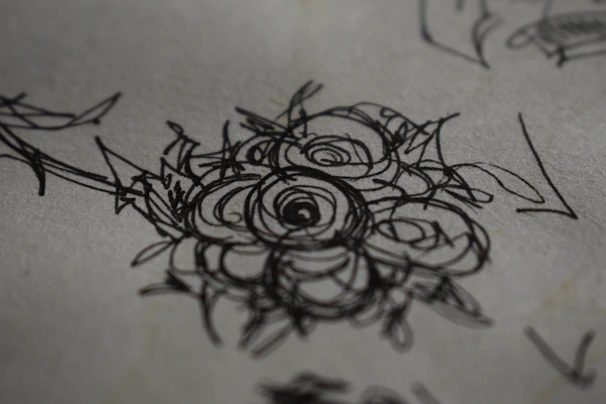An artist's hand sketching a lively floral design using Coloris markers on textured paper