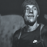 A Jam Ras logo embroidered on a hat, glowing softly in natural light.