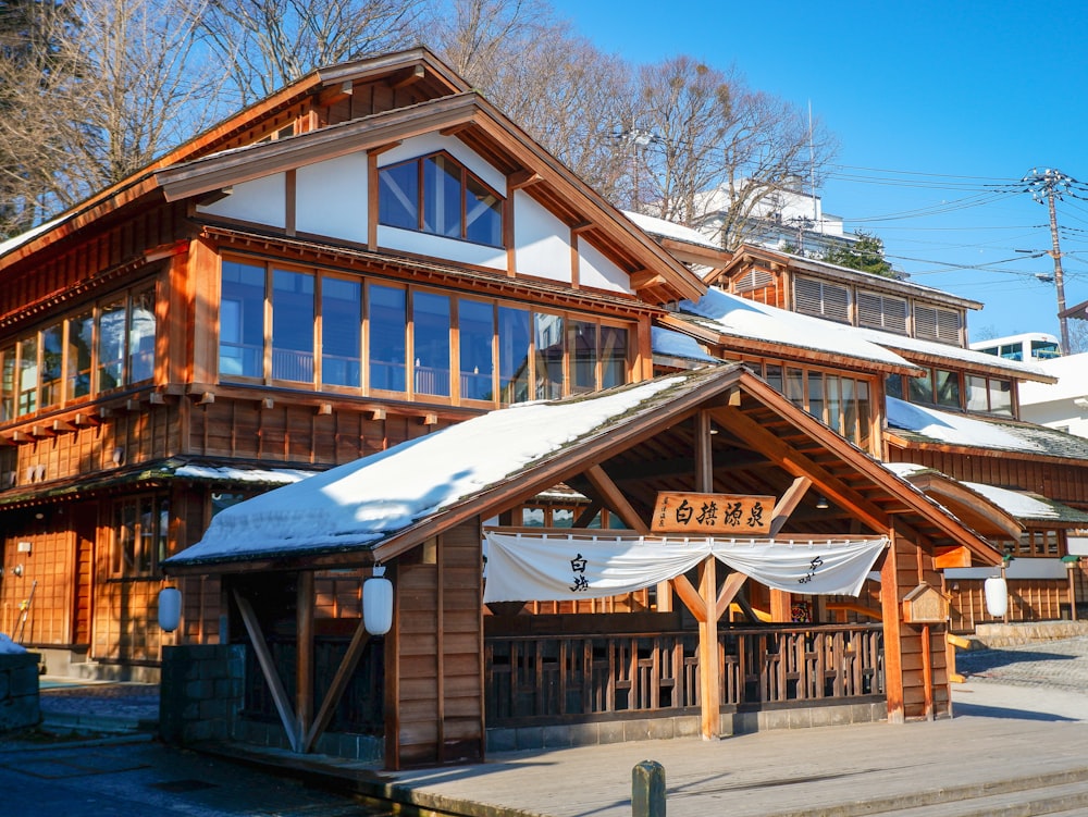 昼間の木の近くの茶色の木造住宅