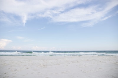 A tranquil beach with soft waves and clear skies.