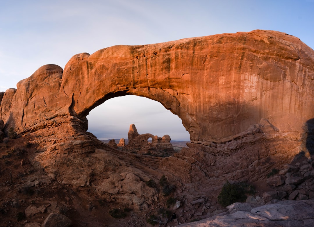 people sitting on brown rock formation during daytime