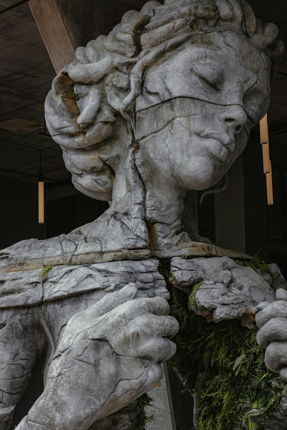 estatua de hormigón gris del hombre que sostiene el palo