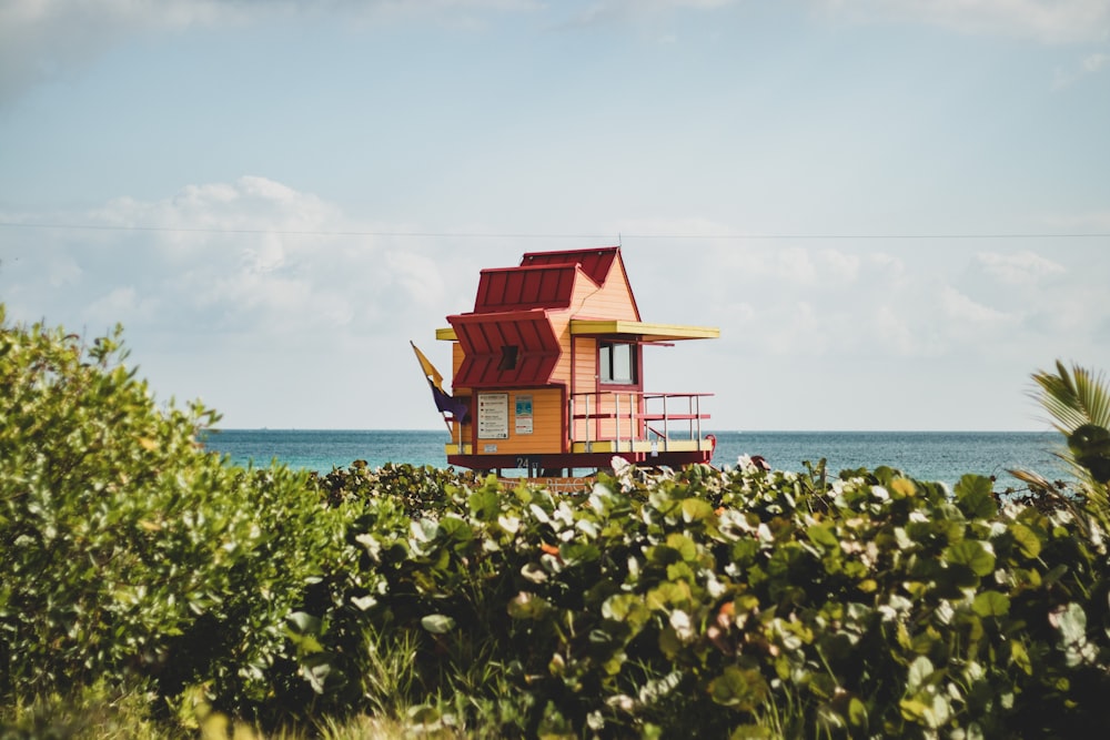 red and blue wooden house near body of water during daytime