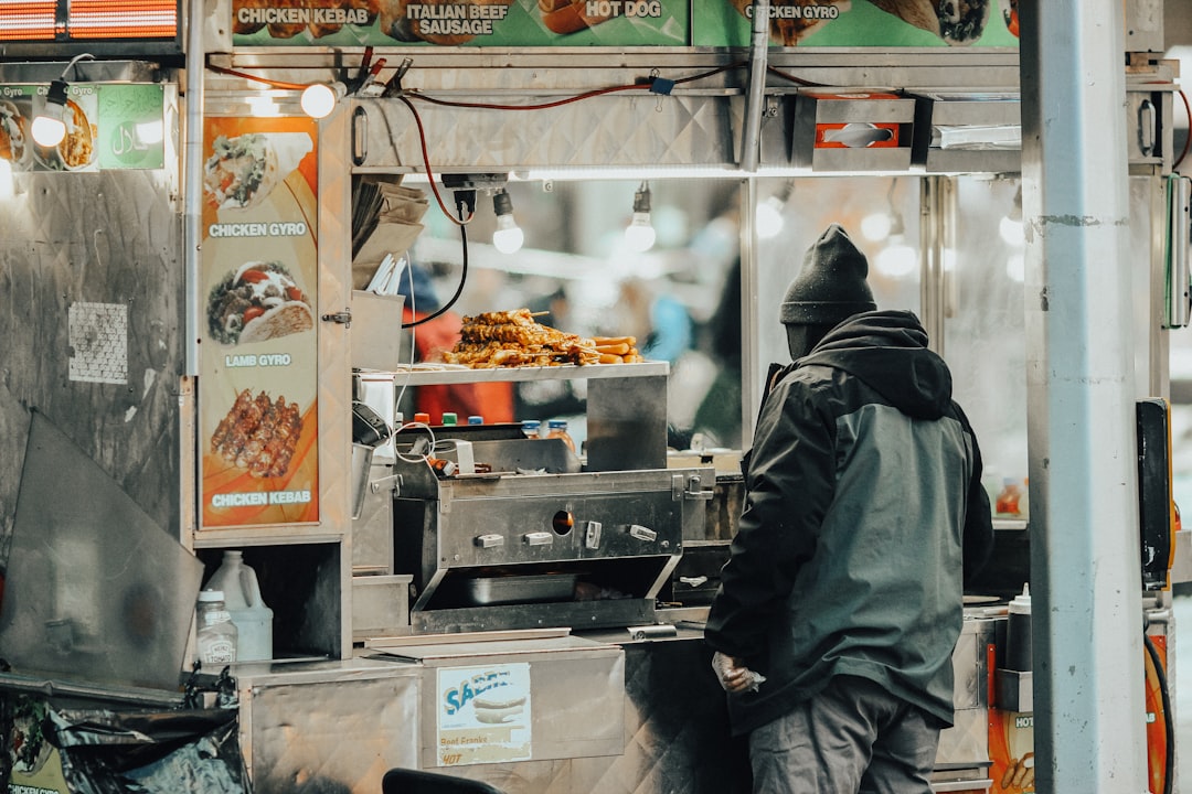 person in black and gray hoodie standing in front of food display