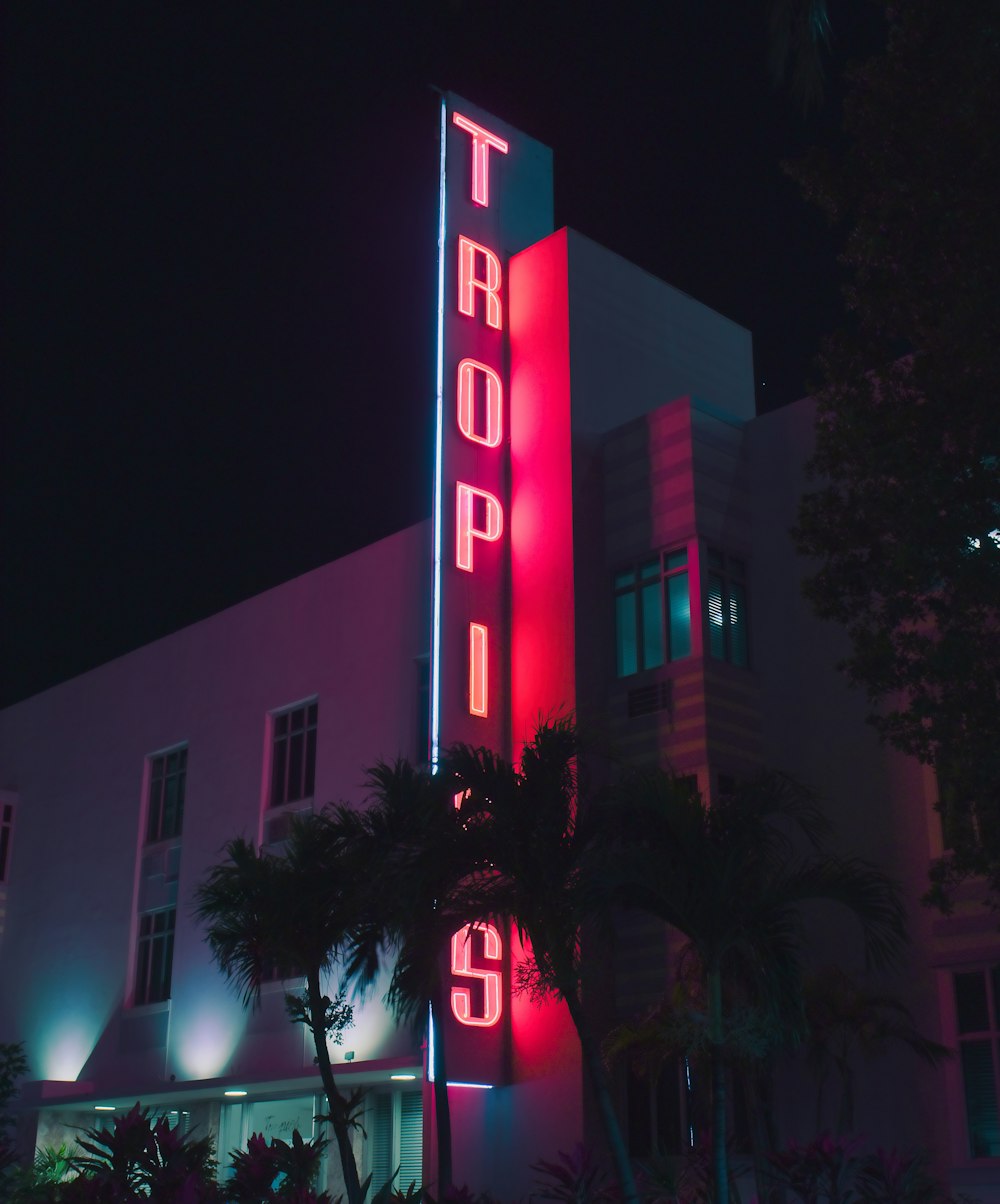 a tall building with a neon sign on it's side