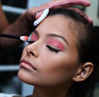 woman with pink lipstick holding white and purple toothbrush