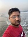 man in red crew neck shirt wearing eyeglasses