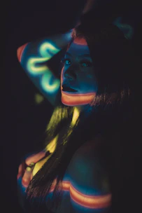 A neon-lit live cam performer engaging with viewers in a cyberpunk room.