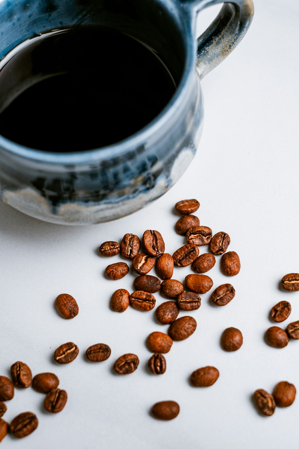 granos de café sobre mesa blanca