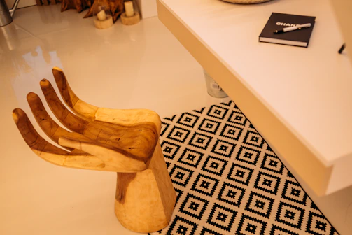 A cozy workshop corner showcasing handwoven Majuli cane chairs and a vintage wooden desk with a contact notebook.